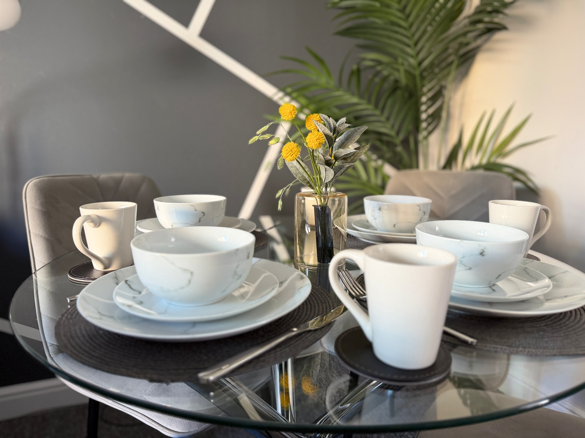Century House dining table set for four with marble-pattern crockery and fresh flowers